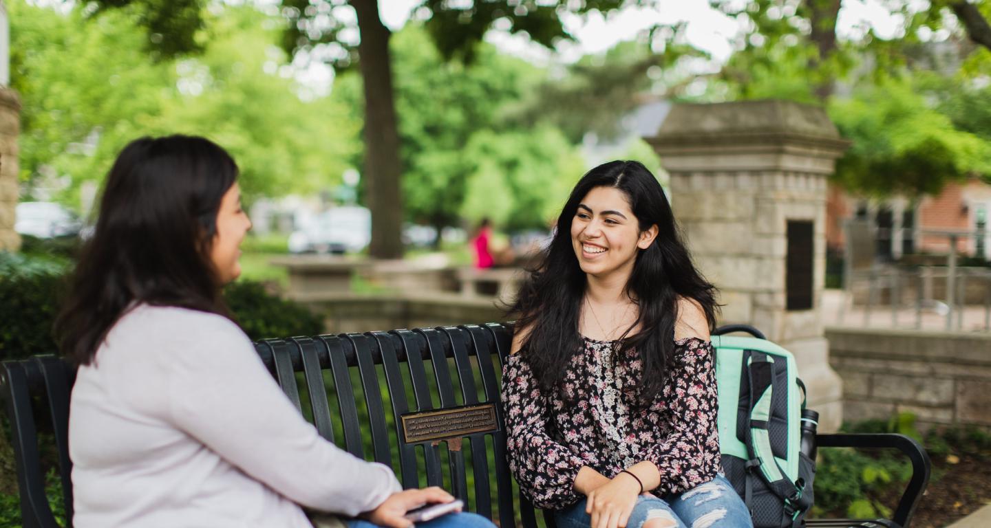 students talking on a bench